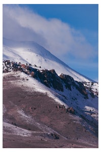 a mountain covered in snow with a blue sky