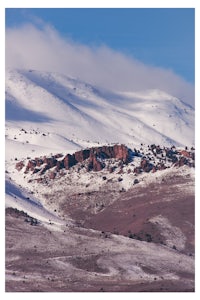 a mountain covered in snow with a blue sky