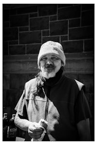 a black and white photo of a man with a beanie