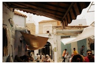 people are walking down a street in a city in morocco