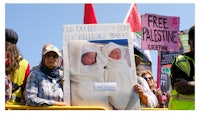 a group of people holding signs in front of a building