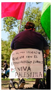 a man in a wheelchair holding a sign