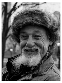 a black and white photo of a man wearing a furry hat