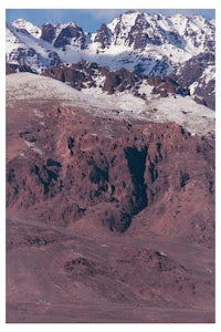 a person is flying a plane over a mountain range