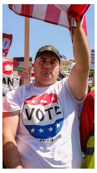 a man holding up a t - shirt that says vote