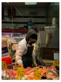 a man wearing a mask in a fish market